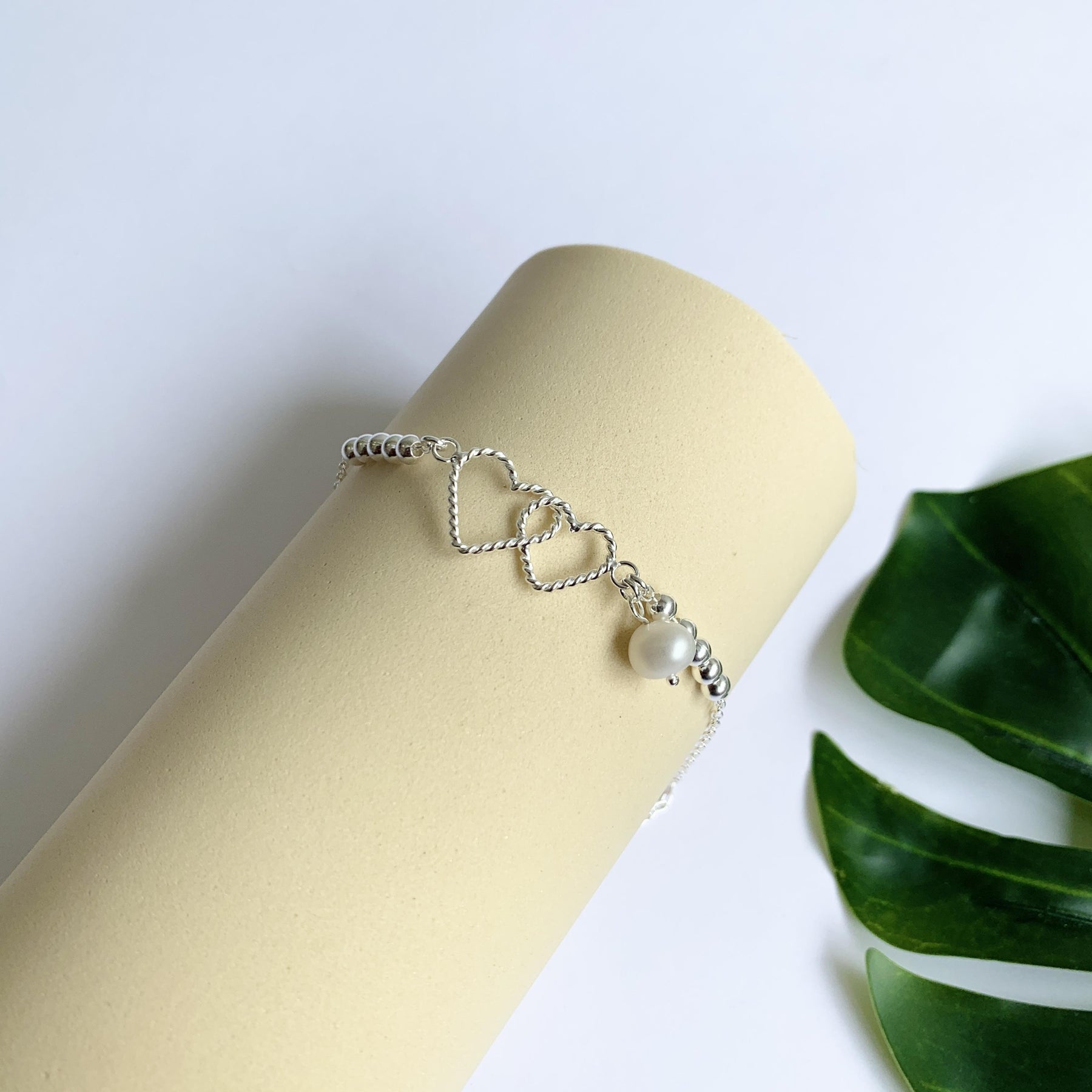 PULSEIRA CORAÇÕES ENTRELAÇADOS E UMA PEROLA